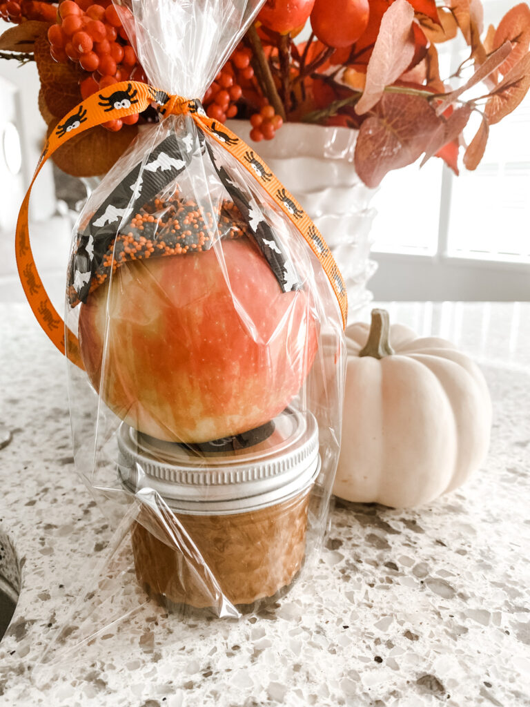 caramel apple kit in a clear cellophane bag with a ribbon