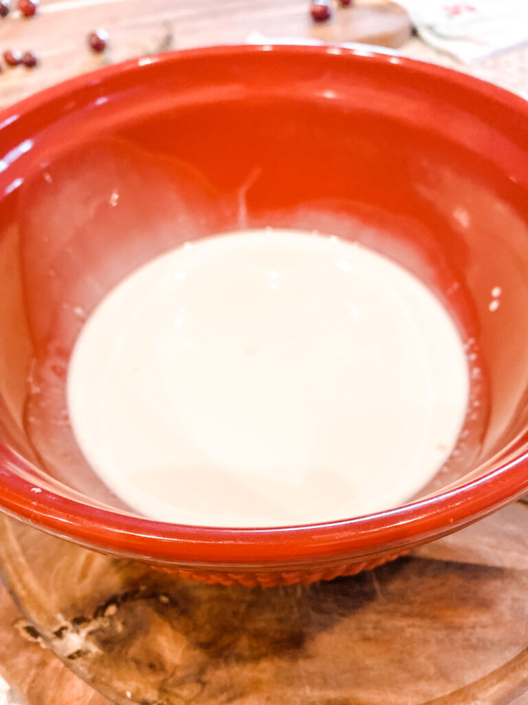 Heavy cream and maple syrup in red bowl. 
