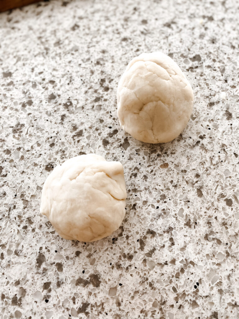 two balls of white play dough on a counter