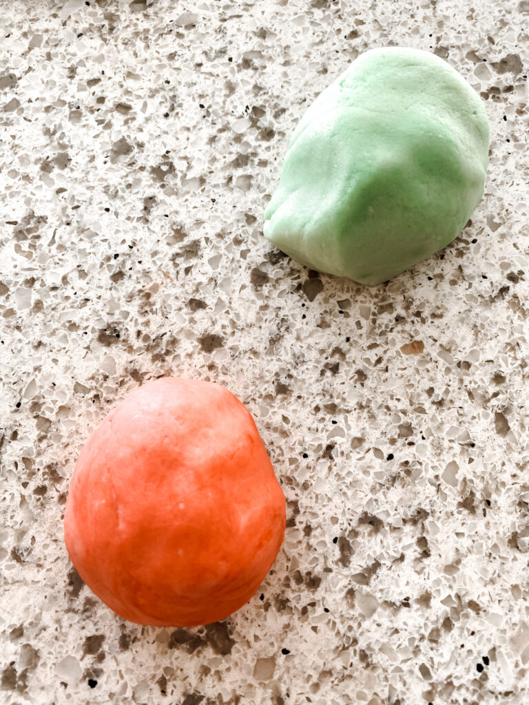 red and green homemade playdough on a counter