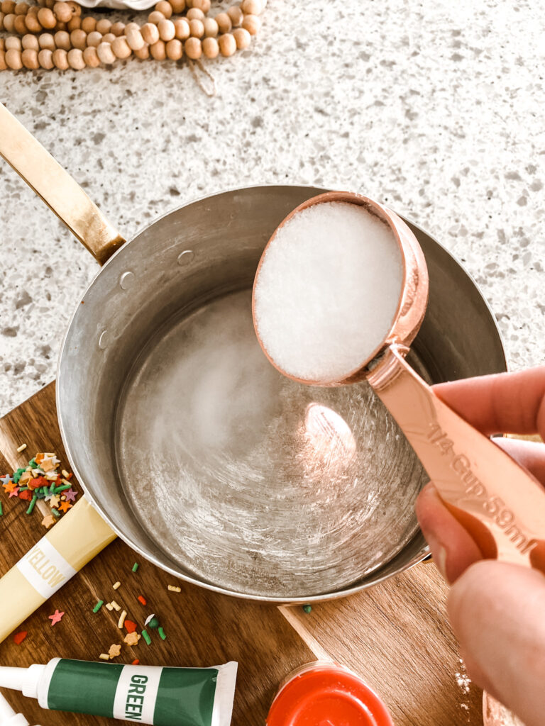 measuring cup of salt being poured into a copper pot of water