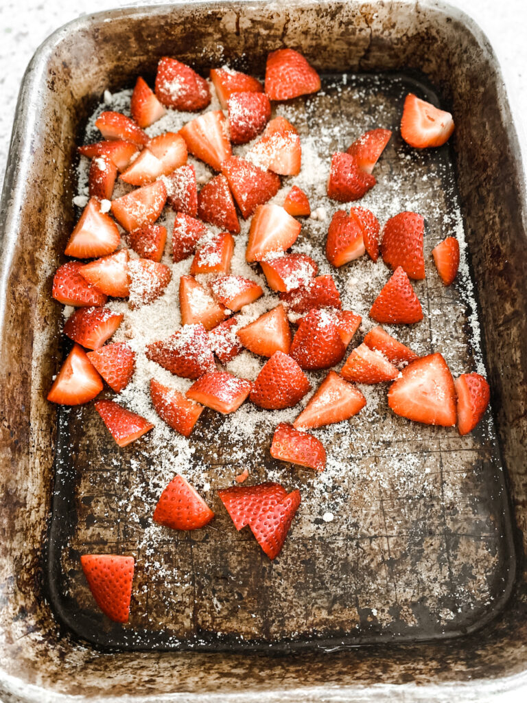 Chopped strawberries in a baking pan with sugar on top 